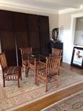 Old Hickory 42" glass top round dining table and four chairs shown in front of the McGuire panel screen