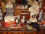 Vintage items on bedroom dresser: dolls, jewelry boxes and more