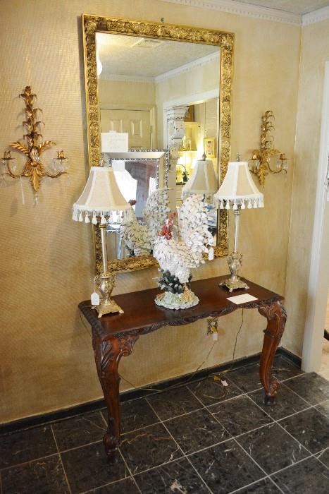 mahogany entry table with tall lamps and ornate mirror
