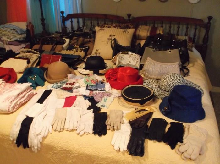King size bed and lots of  vintage handbags, hats, and gloves