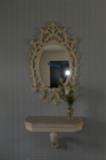 Decorative mirror with stone-topped shelf.