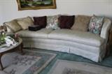 This sofa has a graceful curved shape. The pillows may be sold separately.