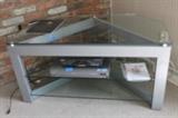 TV stand with two lower shelves, designed to fit in a corner, and 5-disc DVD changer.