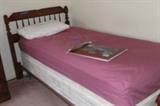 Twin bed with wood headboard.