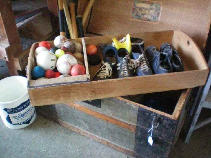 Toy chests with old sports equipment including wooden bats.