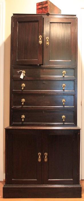 Early 20th century bureau, stamped "REGd W", lined with green felt, brass petal pulls, 4 drawers, top + bottom cabinets. Used for storing silver.