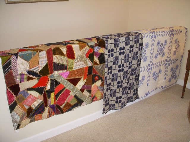 Crazy quilt, 1850's era blue & white coverlet, and cross-stitched quilt