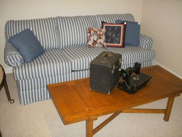 Sofa is a hide-a-bed.  Coffee table displays Singer Featherweight machine