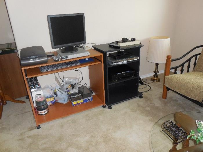 computer desk, stereo cabinet, RCA DVD player, Samsung monitor, JVC VHS player, stereo cabinet, portable computer desk, etc.