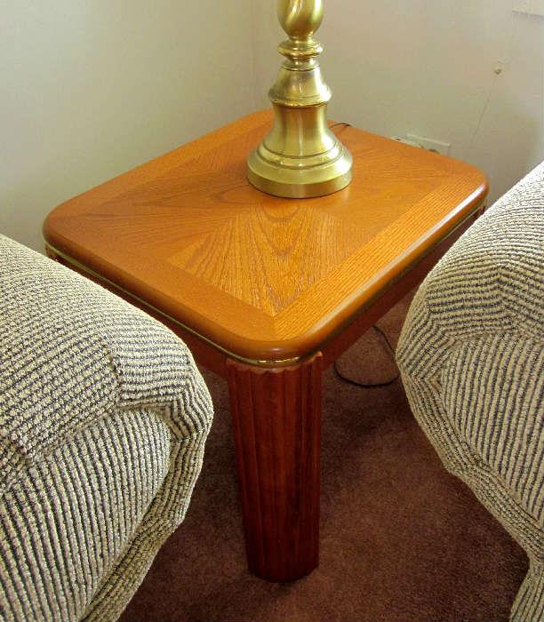 Two wood end tables with goldtone trim and rounded corners.