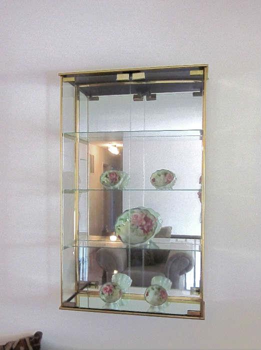 Very nice, large wall mount or table top curio cabinet.  Brass frame, two doors, glass shelves and mirrored back.  Measures 19" wide, 31" tall and 7" deep.
