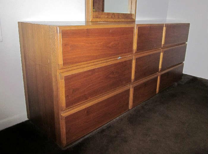 Mid-Century Modern triple dresser of light and dark Oak with 9 drawers and matching, attached, mirror by Lane.