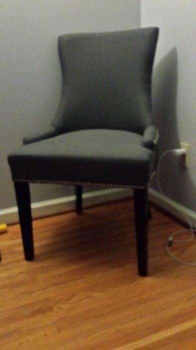 New medium, gray upholstered chair.  Black legs, silver upholstery tack trip on bottom and sides.
