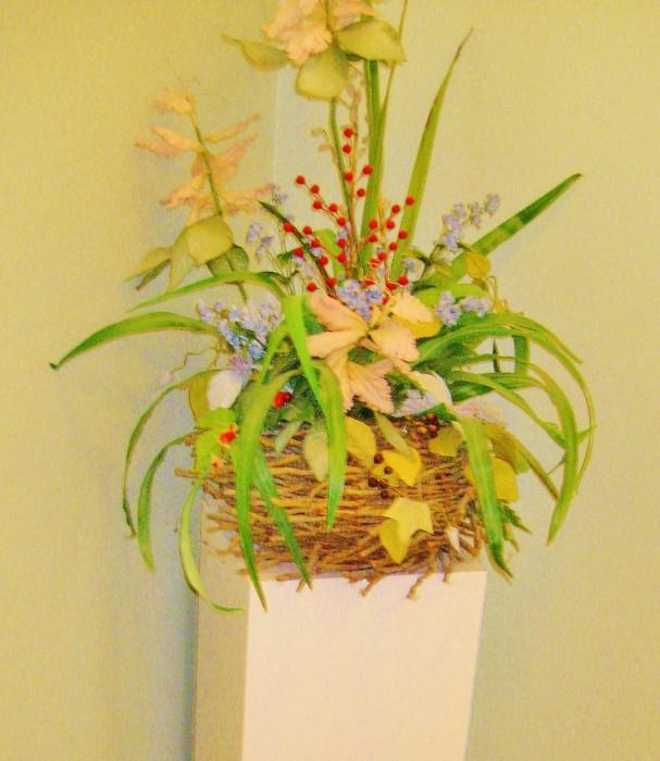 Silk flower arrangement on display pedestal