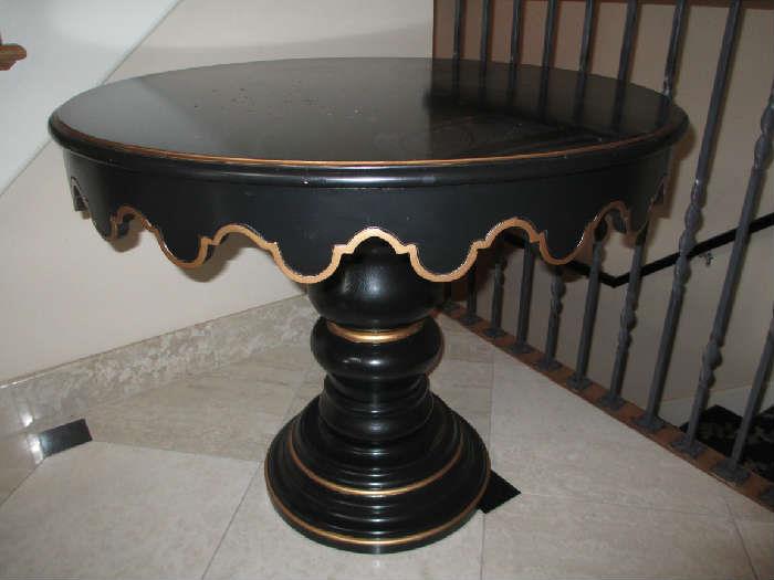 CUSTOM ROUND BLACK SCALLOPED TABLE WITH GOLD ACCENTS  TURNED PEDESTAL ON ROUND BASE.

