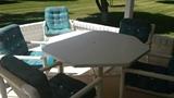 Patio table. Extra chair w/ ottoman in the background.