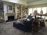 Pair of denim-covered chairs and ottomans, hearth guard and fireplace tools, pair of table lamps, book collection