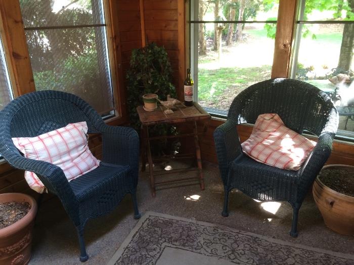 Screened porch full of casual furniture and décor.