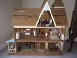 Large wooden dollhouse full of furniture and accessories.