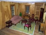 Large wooden dollhouse full of furniture and accessories.