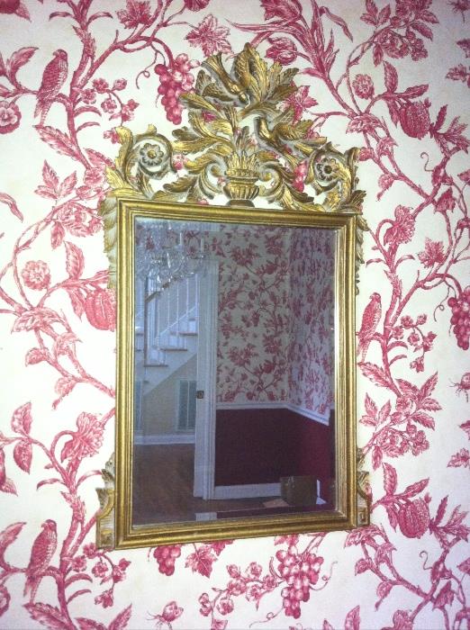 Wall mirror in ornate gold-tone frame.