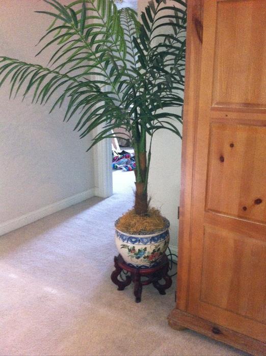 Decorative pot with stand and faux plant.