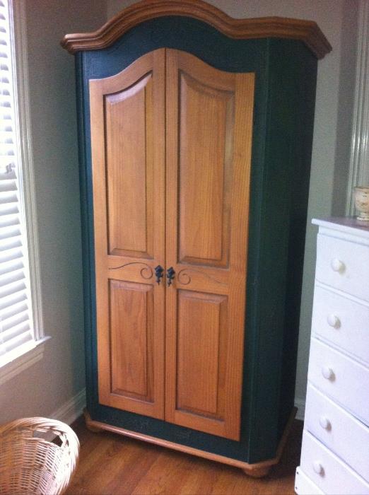 Armoire in natural wood with painted accent.