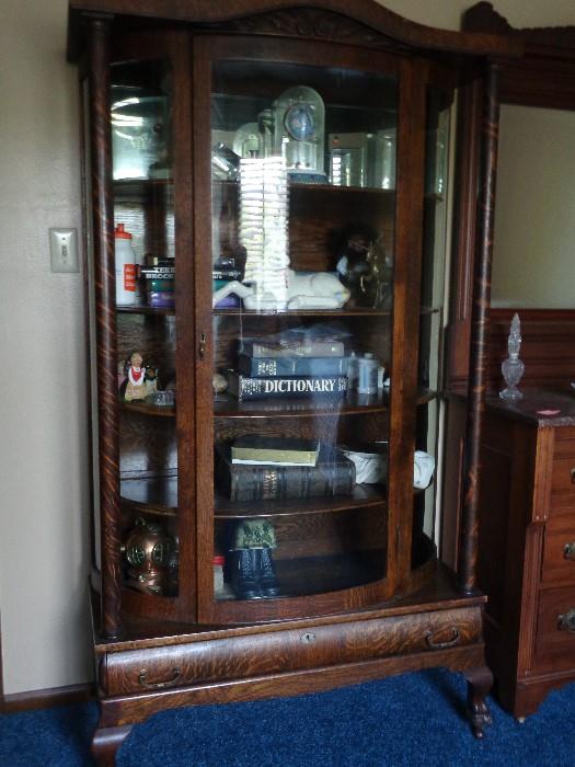 Antique tiger oak china cabinet on casters in excellent condition.  71 inches tall; 37 inches wide; 15 inches deep; drawer on the bottom with original handles; 4 wood shelves -- mirror on the back.