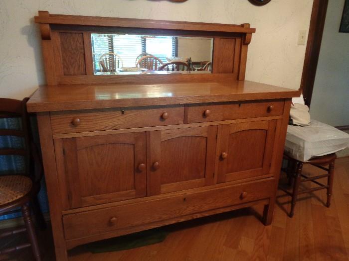 Oak buffet with mirror backsplash circa 1900.  Matching round oak table with 3 leaves, rocker and oak mirror also available.  All pieces in excellent condition -- been in my family for 3 generations.