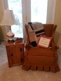 Recliner rocker next to vegetable bin but used as a table.  Vintage tamp with autumn leaf design.  