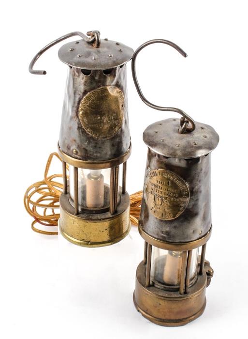 Lot #91, Pair Antique Brass Steel Electric Miner's Lantern
 A unique pair of brass and steel electric miner's lanterns. Wiring has been spliced together so the lamps operate on one electrical plug. The lamps are similar in design with a brass base, glass enclosed bulb socket, pressed steel top housing and wire hook handle. Both lamps have some minor dents and dings but display beautifully. Working condition not determined. Each measures 9.5" tall with a diameter just shy of 3.5". Brass emblem's on the lamp are slightly different: - Protector Lamp & Lighting Co., Ltd. - Type S.L. - No. 166 - Eccles, Manchester. - Protector Lamp & Lighting Co., Ltd. - Type 6, Ministry of Power Safety Lamps - Approval No. B/28 - 199 - Eccles. Tag words: Davy lamp, Geordie lamp, Safety lamp, lighting