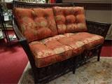 Two rattan loveseats with cinnabar and gold cushions, excellent condition