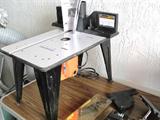 Benchtop Router Table with Router. 1 3/4 HP motor, max speed 20,000 RPMs, Collet Size 1/2", Mitre Gauge 0-60 degrees left and right; table  is 23 3/4" x 14 3/8". Depth scale for precision bit placement; Quick Stop electric brake