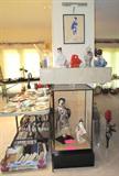 Two excellent Geisha Dolls with Porcelain faces and traditional dress...one is a tall Geisha and the other is small. Both are housed in a large display case. Also shown are other oriental style artwork, vases / urns, and Geisha doll that are also available as are the accent plates and dinnerware shown on the table