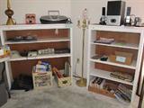 Upright open shelf style book cases with white finishes; Other Items shown like the vintage brass Floor Lamp, the Altec Lansing Speakers, other electronic items, some of the games and books are also available in this sale.
