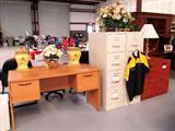 Office Desk with right and left file storage drawers...maple finish. Office chair is also available and is pictured elsewhere in this collection; Also shown are 2 matching metal 4 drawer file cabinets, and 2 matching wood 2 drawer file cabinets with cherry finish; Floral arrangements, lamp, and Simms Racing shirt are also available