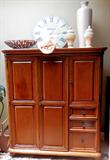 Lovely Vintage Armoire  with fold out double doors, gliding shelves, and  lots of drawers &  doors storage with brass pulls,  and rich mahogany finish. Accent Pottery and large dish as well as the retro Bombay clock are also available