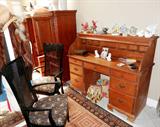 Vintage Rolltop Desk with 7 drawers storage with brass pulls, plus large rolltop area and mail/ letter slot storage.  Desk has a maple color finish.  Also shown are two  matching cane back arm chairs with floral print pattern upholstered seats; Also shown is the lovely Vintage Armoire which is pictured separately in other pictures in this collection.   Also shown are some of the collection of figurines...porcelain / china birds...by Lefton, Andrea by Sadek, Gorman, others which are also available.