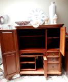 Lovely Vintage Armoire  with fold out double doors, gliding shelves, and  lots of drawers &  doors storage with brass pulls,  and rich mahogany finish. Accent Pottery and large dish as well as the retro Bombay clock are also available