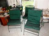 Vintage Wrought Iron Porch / Patio  Set...includes Oval Shaped Wrought Iron Table with green finish,  4 Matching  Wrought Iron  Chairs...that rock.  Chairs  have nicely scrolled metal vine and leaf accents on their backs and also have green cushions.