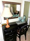 Vintage Bassett Vanity /  Desk with 4 drawers storage and chrome pulls, dark finish.  Desk is matching to  Bassett Queen Size Bedroom Set...Set includes 4 poster bed...Queen Headboard, Footboard with dark finish,  and rails, Queen Pillowtop Serta mattress & Boxsprings, Matching Vintage Bassett High Boy Chest of Drawers with 5 drawers and chrome pulls, Matching Vintage Bassett Night Stand with Drawers & bookshelf storage , Matching Vanity / Desk with 4 drawers storage and chrome pulls; Other items in this set are pictured elsewhere in this collection. Also pictured is a vintage slat backed chair with dark finish and upholstered seat.  Also pictured is an ornate framed beveled wall mirror, a  accent table lamp, and a Vintage Singer Sewing Machine which are also available.