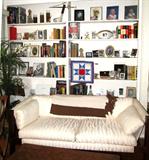 Mid Century Style Sling Style Sofa with wood & metal frame and sling strapping characteristic for this style sofa, and  Off  White colored Upholstery (Likely circa 1960's).  Other Items shown are also available...books (aviation, religious, others), navigational sailing items, etc.