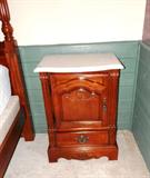 One of Two Matching End Tables by Stanley Furniture with marble tops, door and drawer storage with brass pulls, and pressed decor accents..  End Tables are part of Stanley Furniture Bedroom Set that includes  Four Poster Style King Size Bed Set...King Size Four Poster Style Headboard & Footboard, frame, King Size Mattress & Boxsprings and matching End Tables.  The other matching end table is pictured elsewhere in this collection.