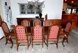 Large Beautiful Mediterranean Style Dining Set...Large Dining Table with with nicely carved  Parquet accents and sculpted top, rich finish, nicely carved legs with paw accented feet, and nicely turned stretchers, two extra leaves; 10 Dining Chairs...2 high backed Arm Chairs and 8 High Backed Side Chairs. Chairs have beautiful rose and pink colored upholstered seats and backs; Also shown is a Home Collection Mediterranean Style Side Board / Buffet with rich finish and doored and drawers storage; Pair of Matching Ornate wall Metal Sculptures are also available.