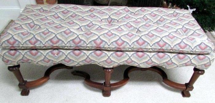 Upholstered bench with flame-stitch fabric, 
tufted top, and curved wood base.
