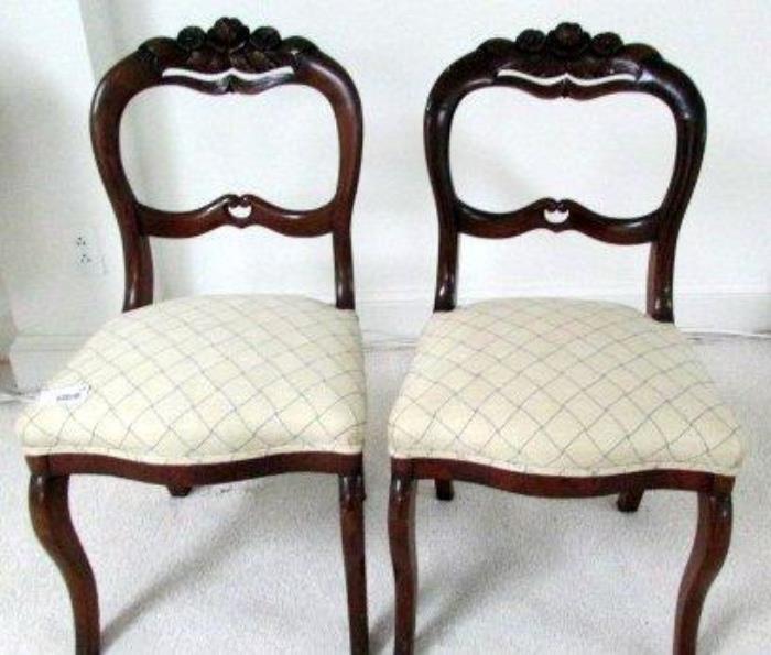 Pair of Victorian style armless chairs 
Carved floral area at top of ached seat back 
Ivory basketweave patterned seat cushions 
