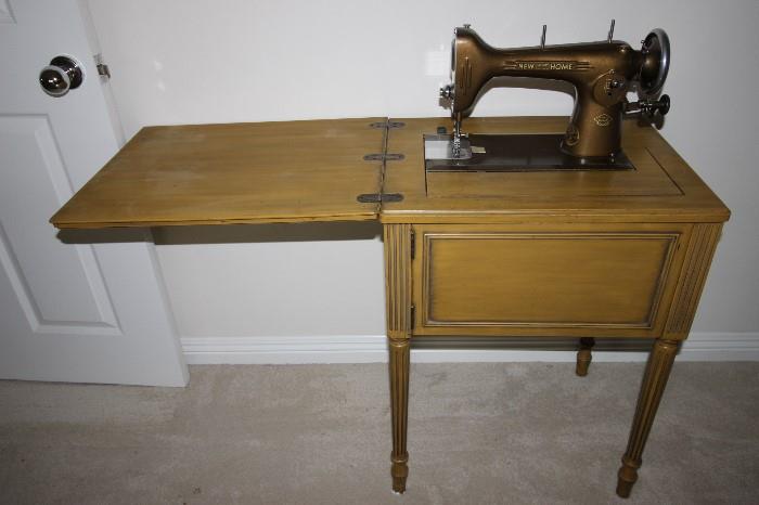 New Home sewing machine in cabinet.