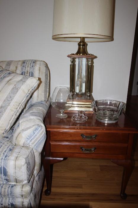 End table with drawer, large table lamp and glass pieces.