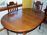 Oak finish Dining Room Table with six matching chairs & extra leaf.