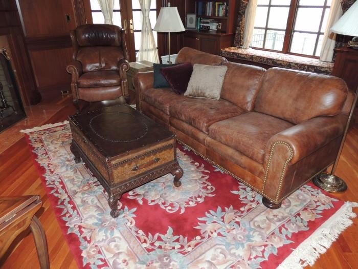 Carved Aubusson wool rug, trunk table, leather sofa and recliner, stiffel floor lamps
